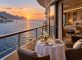 Suite con balcón y mesa gastronómica en un crucero de lujo al atardecer